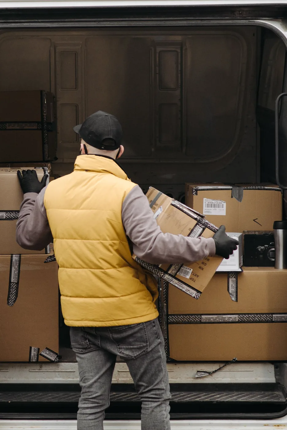 A delivery worker organizing packages in a van