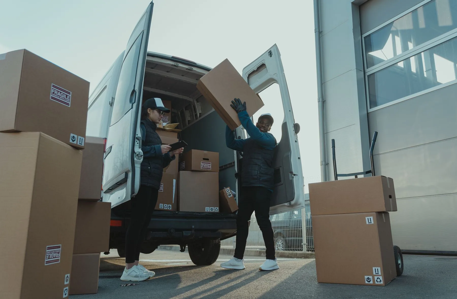 Workers loading parcels into a delivery van